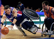 Νο10 Frederic Guyot of France dives for the ball while Νο13 Rene Martens of the Netherlands watches on during the Wheelchair Basketball match between France and the Netherlands held at the Sydney Superdome during the Sydney 2000 Paralympic Games.  Scott Barbour / Allsport