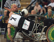 George Hucks of Australia retains the ball as Timothy Johnson of New Zealand falls from his wheelchair during the Rugby Wheelchair semi final game at the 2000 Paralympic Games in Sydney.  Scott Barbour/Allsport